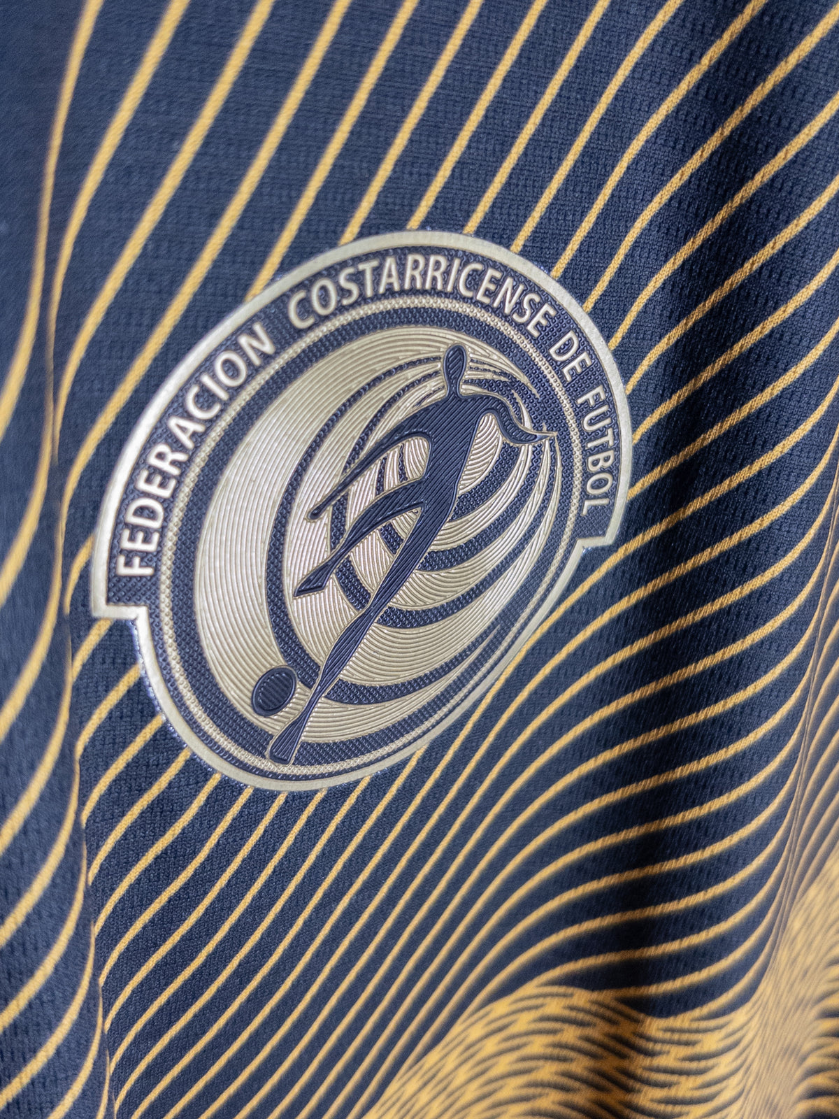 Detalle del escudo en la camiseta negra y dorada de Costa Rica New Balance 2019